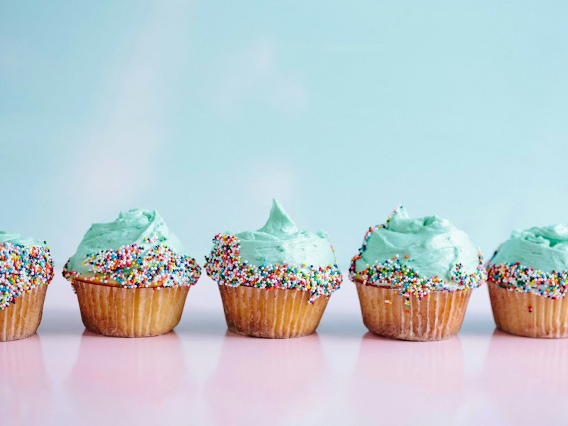 Six teal icing cupcakes with sprinkles