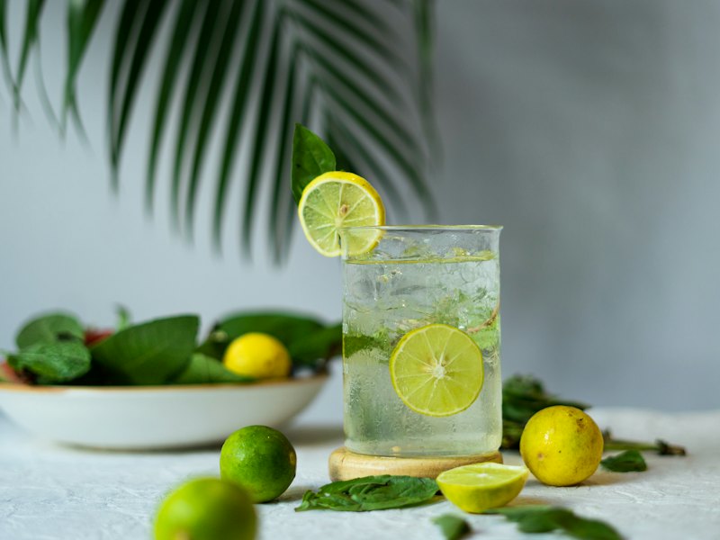 A glass of lemonade with limes and limes